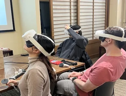 A photo of 3 students wearing VR headsets and engaging in a VR activity.