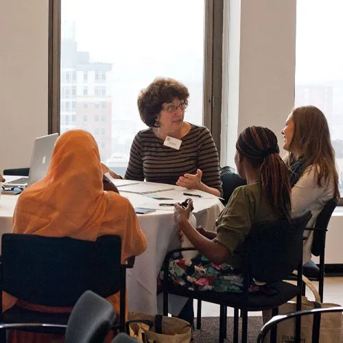 Alla Smyslova, Instructor of Russian, engages in conversation with three students.