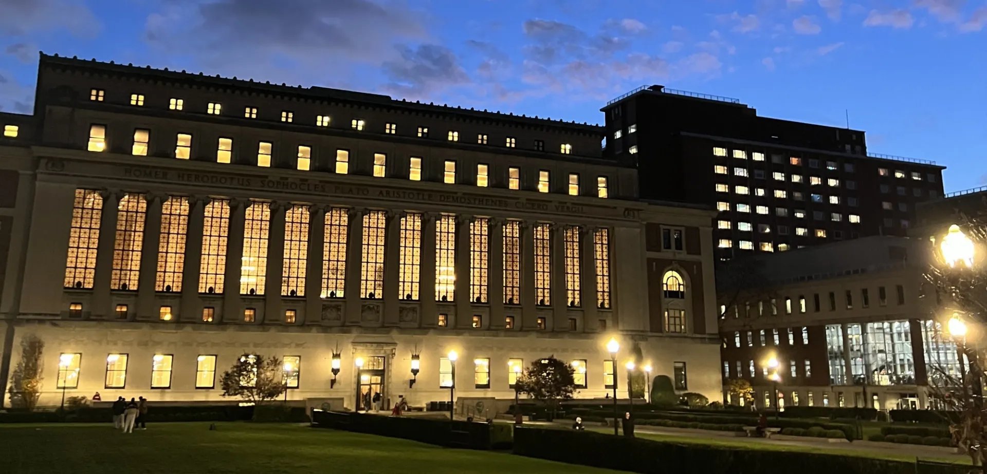 Butler Library at twilight. The windows are brightly lit.