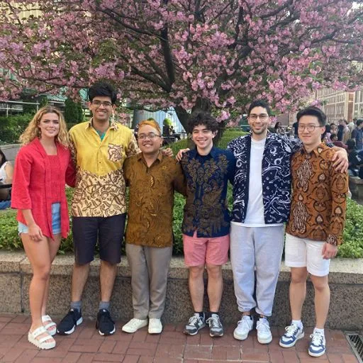 Indonesian students at the Indonesian Culture Day on the bridge over Amsterdam Avenue in front of a flowering tree.