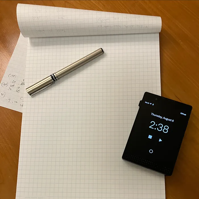 An open notebook with a pen and a smartphone