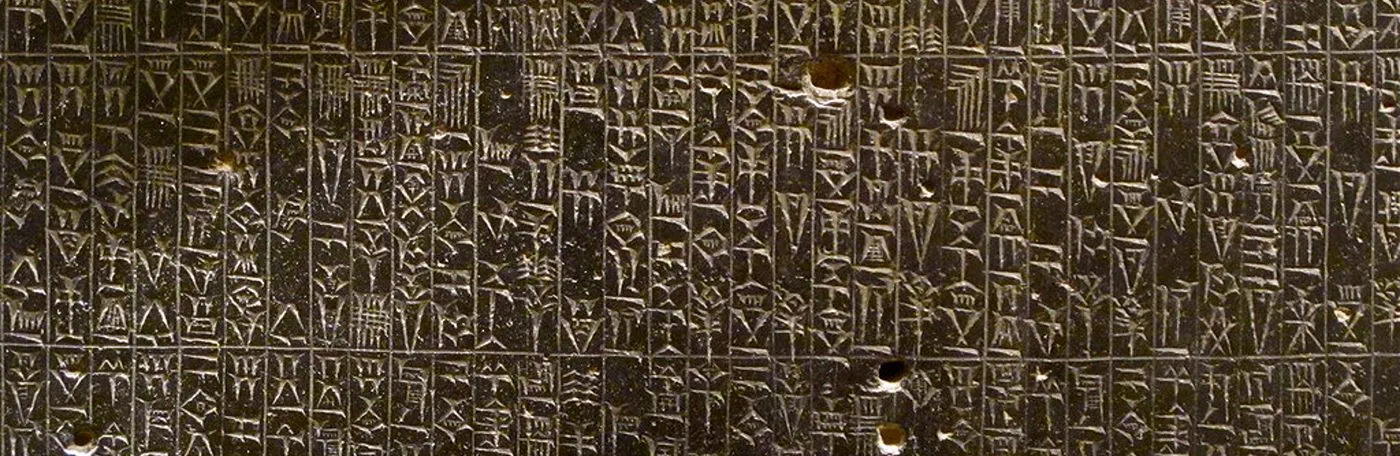A background of Akkadian cuneiform script carved into dark stone.