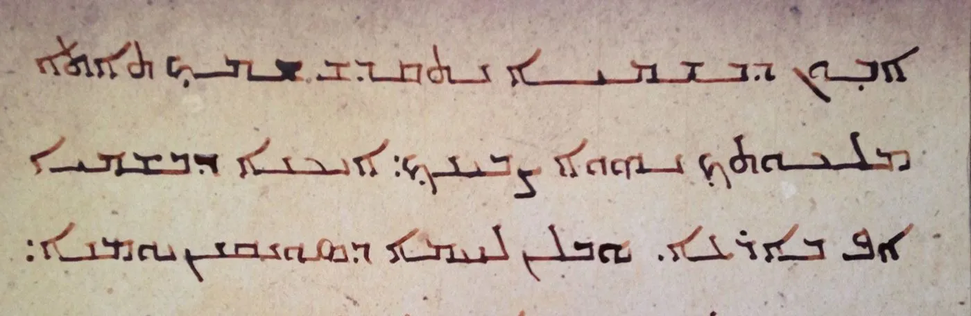 Three lines of Aramaic text written in ink on a sheet of parchment.
